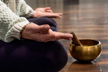 Yoga yaparken Tibet şarkı kasesiyle meditasyon yapan bir kadın.. 