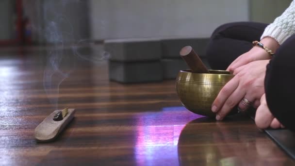 チベット語の歌のボウルと燃焼香りスティックと女性の瞑想マットでヨガを練習中高品質のフルHd映像 — ストック動画