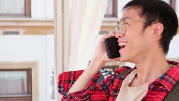 Young Asian Man Red Shirt Holding Smartphone Talking Phone Friend — Αρχείο Βίντεο