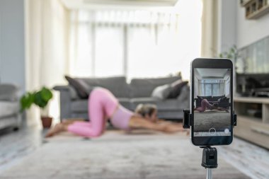 Yoga yapan kadın, telefon kamerasının önünde poz veriyor spor blogcusu öğretmen yoga online sınıf sağlık koçu