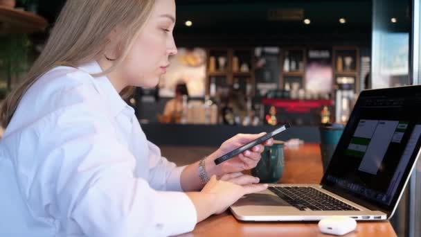 Jovem Mulher Camisa Branca Sentada Café Com Telefone Mãos Digitando — Vídeo de Stock