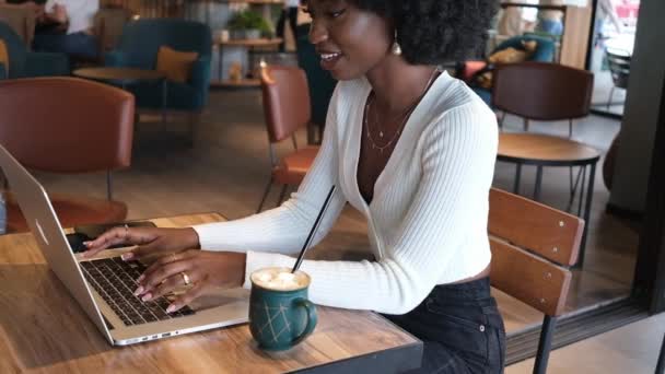 Happy African American Kobieta Siedzi Kawiarni Pije Kawę Pracuje Laptopie — Wideo stockowe