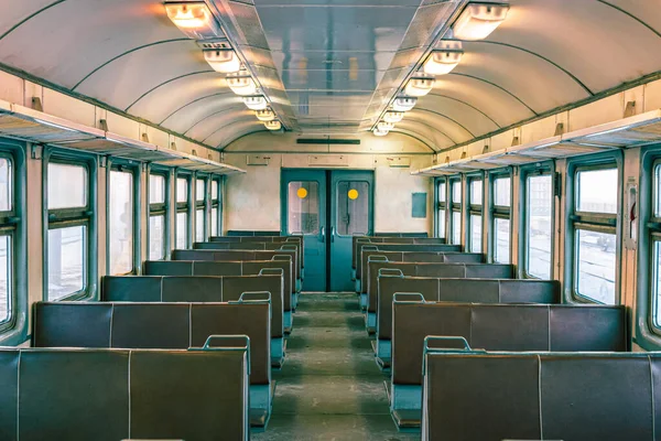 Empty cabin of old passenger electric train. Empty leather seats inside train cabin, corridor view, no people. economy class fast train interior.