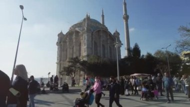 Ortakoy Camii 'nde insanlar yürüyor, meydanda oturuyor. Türkiye İstanbul Eylül 2021