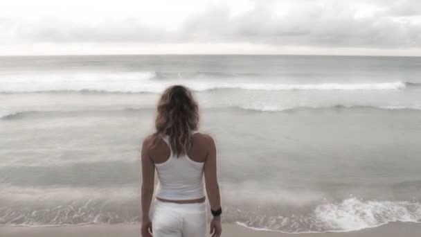 Woman walking slowly toward the sea — Stock Video