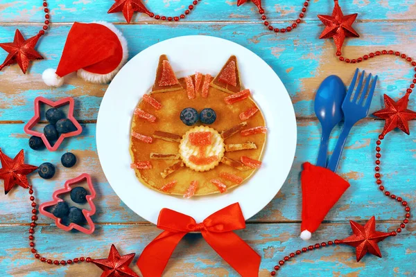 Comida divertida para crianças. Símbolo do ano novo do tigre. Panquecas em forma de tigre na mesa de madeira azul, vista superior. Alimentação saudável para crianças. Ideia criativa para crianças café da manhã Imagens Royalty-Free