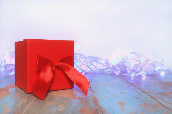 Scatola regalo rossa su tavolo in legno sfondo bianco. Vacanza, celebrazione, Copia spazio, spazio per il testo — Foto Stock