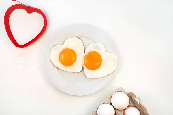Micul dejun romantic. Ouă prăjite în formă de inimă pe o farfurie. — Fotografie, imagine de stoc