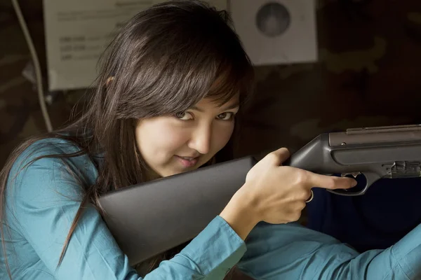 La bella ragazza in un trattino con una pistola Immagine Stock