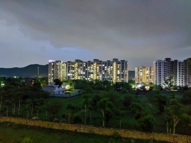 Jaipur, Hindistan 2021: Gökyüzünde bulutlara karşı çekilen ağaçlı ve binalı şehir manzarası