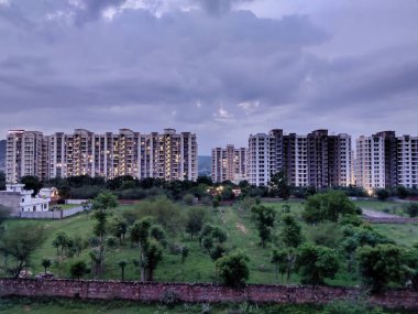 Jaipur, Hindistan 2021: Gökyüzünde bulutlara karşı çekilen ağaçlı ve binalı şehir manzarası