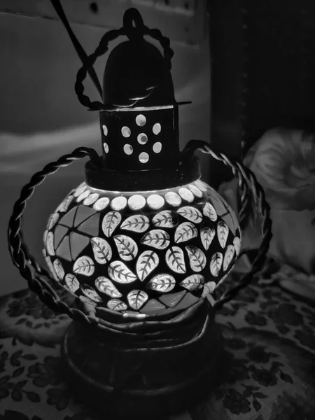 Gece çekilen sehpanın üzerinde yatağın yanında güzel bir gece lambası resmi.