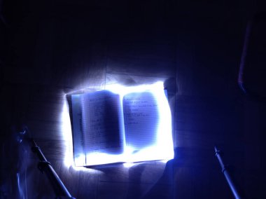Gece siyah arka planda el feneri ile çekilen bir kitabın etrafında oluşan bir desen. Uzun pozlama fotoğrafçılığı uzun deklanşör hızı