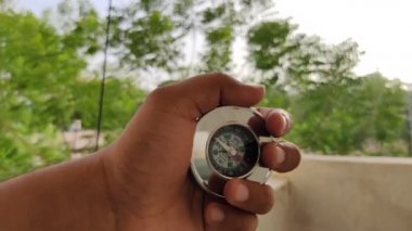 Yaz aylarında gezginlerin yönlerini belirlemek için kullandıkları güpegündüz bulanık arkaplandaki metalden yapılmış bir pusula görüntüleri
