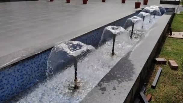 夏の日中に撮影された小さな青い池に水が出てくる噴水の映像 — ストック動画
