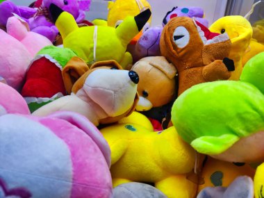 Oyun sahasına atılan pençe makinesinin içindeki yumuşak oyuncakların görüntüsü