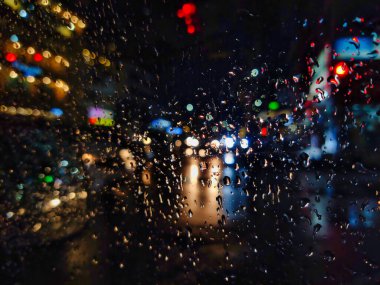 Yağmur mevsiminde yağmurlu bir gecede cam bir kadehte makro su damlacıkları.