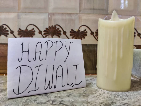 Yanmış mum resmi. Diwali Kutlaması. Üzerinde Happy Diwali yazan bir pankart. 
