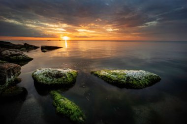 Gün doğumunda deniz taşar. Bulgaristan 'ın Karadeniz kıyısında mavi saatte muhteşem bir gün doğumu manzarası