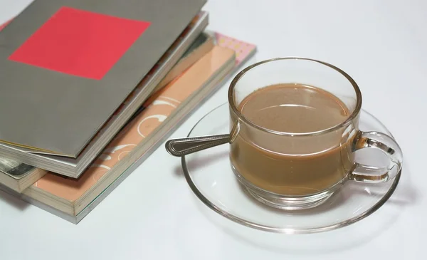 Books and cup of coffee on white background — Stock Photo, Image