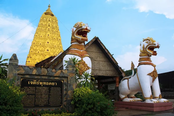 Kanchanaburi - 26 april: twee leeuw beelden en gouden stoepa in de tempel sangklaburi bewaken op april 26,2014 kanchanaburi thailand. — Stockfoto