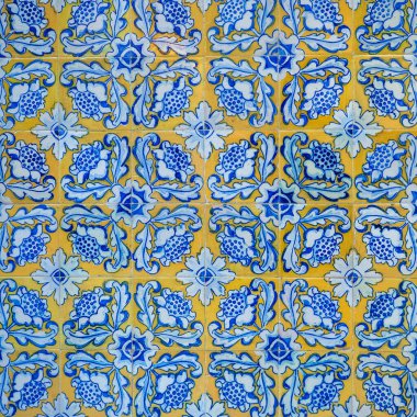 Soyut süs arka planı. Süslü karoları olan eski bir bina duvarı parçası. Mavi sarı süslemeli beyaz fayanslar. Azulejos, geleneksel İspanyol sanatı, mimari tasarım için..