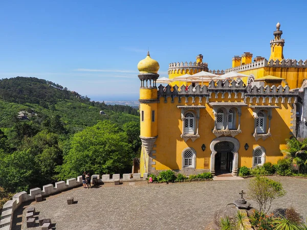 Colorful Pena Palace or Palcio da Pena on the top of a hill in the blue sky background. Exterior of national monument with a variety of architectural styles.