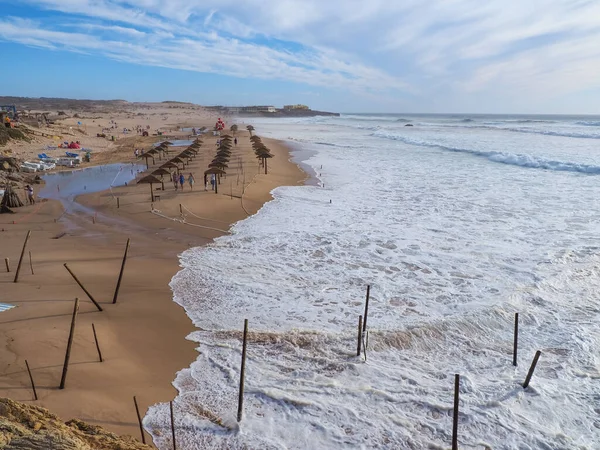 Flooded Guincho beach and stormy Atlantic ocean with white foamy waves. Beautiful landscape in Sintra-Cascais natural park is a reserve on the Portuguese Riviera. Cascais, Portugal.
