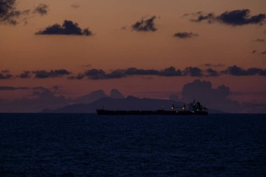 Renkli bir günbatımı bulutlu deniz manzaralı bir gemi.