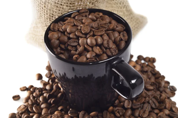 Granos de café en taza negra — Foto de Stock