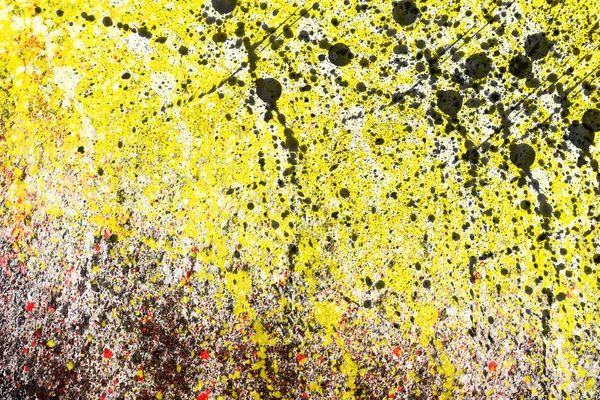 Abstract yellow background with splashes of black, white and red paint — Stock Photo, Image