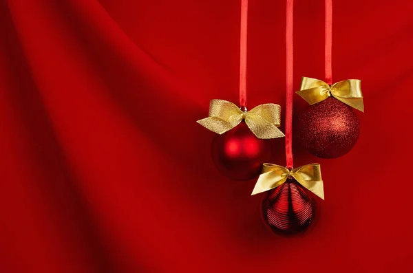 奢华的圣诞装饰 红色的球 金色的蝴蝶结串行挂在红丝窗帘上 波光明媚 复制空间 小册子设计的圣诞背景 — 图库照片