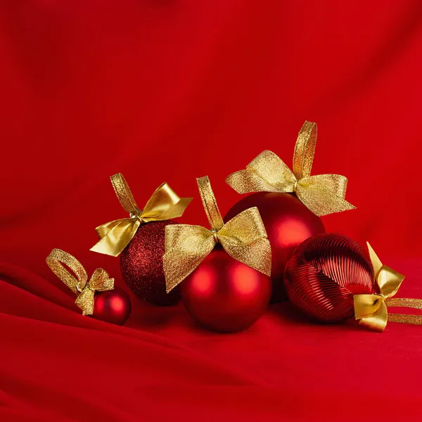 Роскошные Рождественские Шарики Золотыми Бантами Глубоком Красном Шелковом Фоне Волнами — стоковое фото