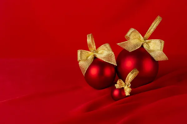 新年背景 色彩艳丽 色彩艳丽的红球 金色的蝴蝶结点缀在飘扬的深红色丝绸缎上 波涛汹涌 复制空间 小册子设计的圣诞背景 — 图库照片