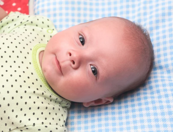 Das glückliche Kind liegt im Bett. — Stockfoto