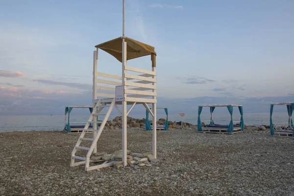 白木の塔を救出する夕日の小石のビーチ無人のビーチ — ストック写真