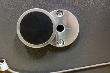 Güvenli bir kapının yuvarlak anahtarı için bir anahtar deliği. Sermaye ve belgeleri koruma kavramı.