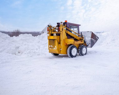 Bölgede küçük bir traktörle kar temizleme. Boşluğu kopyala