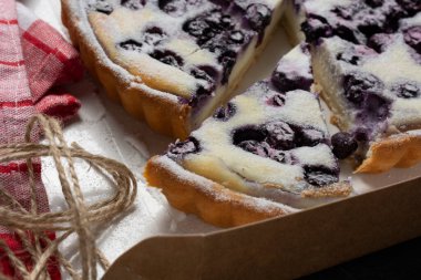 Yakın plan, üzerine pudra şekeri serpiştirilmiş yabanmersinli turta, doğum günü pastası, aile yemeği ve şükran günü konsepti..