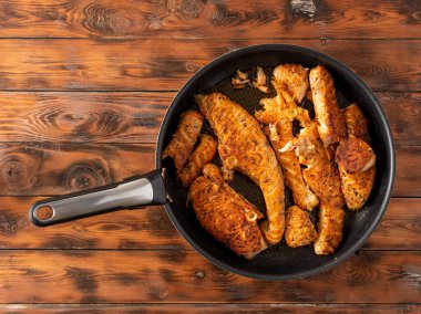 Kızartma tavasında kızartılmış somon parçaları, ahşap arka plan. düz konum.