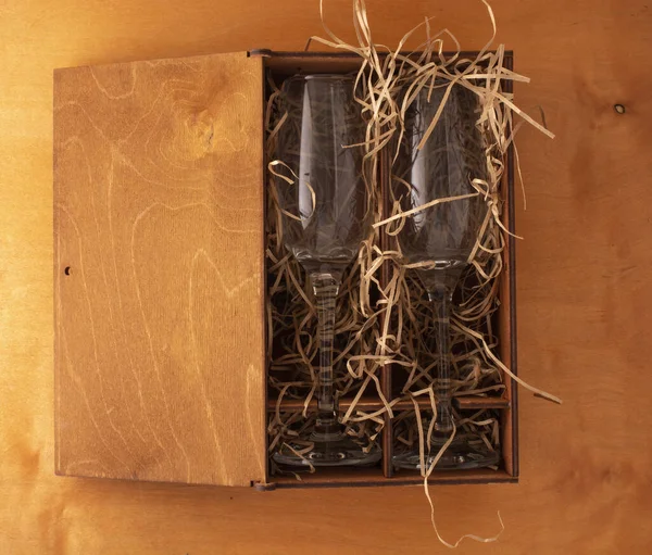 Два бокала шампанского в деревянной подарочной коробке с стружками для мягкости. flatlay — стоковое фото