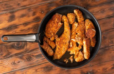 Kızartma tavasında kızartılmış somon parçaları, ahşap arka plan. Düz çizgi.