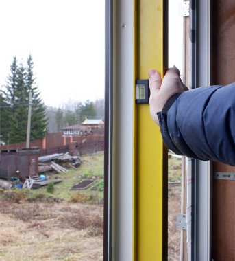 İnşaat işçisi daireye pencere kuruyor. Boşluğu kopyala.