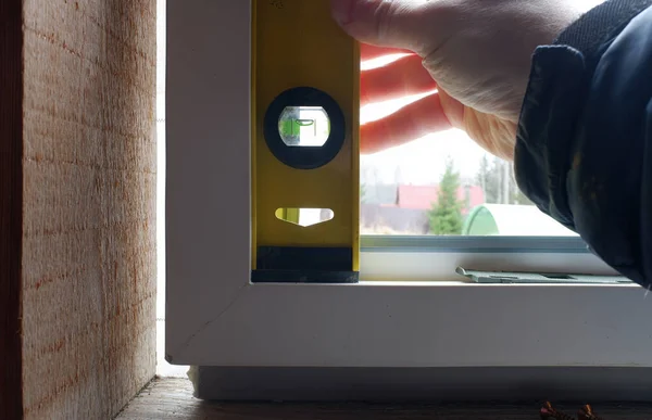 a window installation worker checks the level of the window sill with a special tool. close-up.