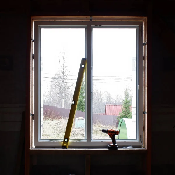 installation of windows in a frame house. the level and the screwdriver on the background of the installed window. copy space.