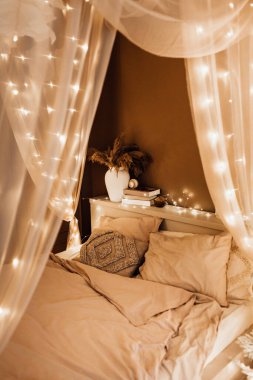 Noel kahverengi oda iç tasarımında sihirli sıcak ve rahat bir akşam, Xmas ağacı süslemeli ışıklar çelenkler tatil oturma odası. Kanepe kemerli kanepe aynası yeni yıl tatili tarzı.