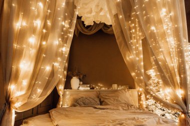 Noel kahverengi oda iç tasarımında sihirli sıcak ve rahat bir akşam, Xmas ağacı süslemeli ışıklar çelenkler tatil oturma odası. Kanepe kemerli kanepe aynası yeni yıl tatili tarzı.
