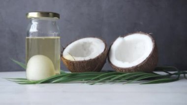 Masada taze hindistan cevizi ve bir şişe yağ var. 