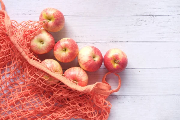 Färskt äpple i en shoppingpåse på träbord — Stockfoto