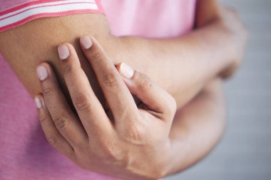 Genç adam dirsek ağrısı çekiyor. 